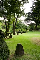 Cothay Manor, Greenham, Somerset. Lawn with trees, shrubs and stone ornaments