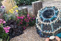 Seaside themed front garden with Lobster pot driftwood and planting includes Phlox, Fuschia, Heuchera and Verbena 