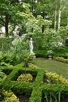 Formal front garden with Buxus, Euonymus fortunei, Cornus kousa var. chinensis, Cornus alba 'Elegantissima', Ligustrum vulgare 'Atrovirens' and sculpture ‘Hebe' in Greek mythology 