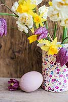 Floral display of Narcissus and Fritillaria meleagris with a painted egg
