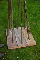 Building a Hazel and Willow obelisk - plank board with stems placed through holes made 