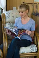 Woman relaxing and reading magazine in summerhouse