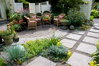 Seating area on Patio with a variety of potted plants.