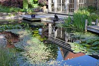 Beautiful pond with decking and house behind