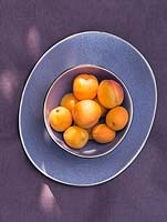 Display of violet tableware with apricots.