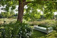 Daybed in the shade of fruit trees in the orchard at Borgo Santo Pietro, Tuscany