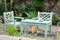 Green painted wooden bench and chairs on patio. Sandhill Farm House, Hampshire