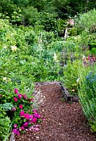 Herb beds mixed with perennials. Jardins des Paradis, Cordes-sur-Ciel, Tarn, France. Designed to encourage children's interest in gardening. 