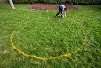 Constructing a circular deck - marking out a deck circle using yellow spray paint