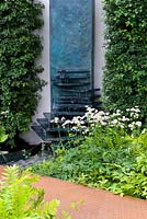 Vertical water feature of patinated green copper. Hawthorn hedge. Osmunda regalis and Astrantia 'Giant White'  RBC Waterscape Garden, gold medal 