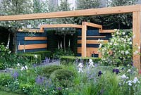 White flowering Viburnum opulus with pine wood structure and naturalistic planting representing Swiss Valais. Grid-shaped plan with conifers. The Extending Space. RHS Chelsea Flower Show 2014. Silver-Gilt medal. 