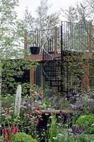 Black spiral staircase surrounded by planting of Anthriscus, Verbascum and Eremurus, Vital Earth The Night Garden 