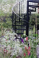 Black spiral staircase surrounded by planting of Anthriscus, Verbascum and Eremurus, Vital Earth The Night Garden