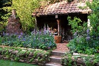 DialAFlight Potter's Garden - Bothy workshop with steps and cottage style border. 