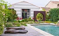 Modern contemporary garden with decking, metal 'Oculus' circle and swimming 