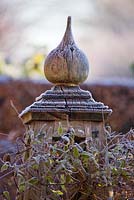 Close up of finial of beautiful oak tripod for climbing plants in the old garden by the back of the house