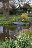 The Beth Chatto Garden with lake, Leucojum and Lysichiton americanus