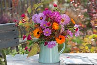 Colourful mixed late summer bouquet on garden table with calendula and cosmos