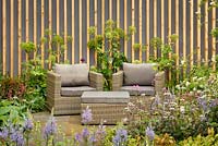 Seating area, mixed border planting and Angelica archangelica against timber screening, 'Bringing Nature Home', show garden, RHS Malvern Spring Festival 2014