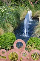 Copper plated fence with a view to a water feature. Garden: QEF Garden for Joy