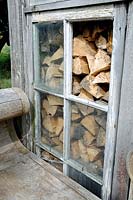 Logs of wood seen through window of allotment shed or hut, Golf Course Allotments, London Borough of Haringey