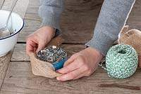 Bird food step by step - wrapping hessian around old tin can 