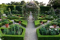 Aerial view of parterre garden with romantic English traditional style with layout of box hedging infilled with peonies and a central arbour covered with climbing roses including Rosa 'Awakening'  - Seend, Wiltshire