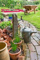 Reclaimed brick path with standpipe and galvanised watering can.