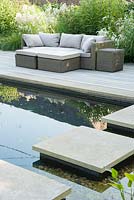 Stepping stones across the pond to decking with seating. Old Rectory, Batcombe, Somerset, UK