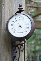 Outdoor wall hanging thermometer showing freezing