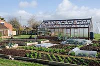 View of the greenhouse and vegetable beds in Spring
