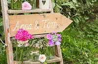 Wedding sign on ladder accompanied with Hydrangea flowers, Scented pelargoniums, Rosa and Dianthus barbatus. 