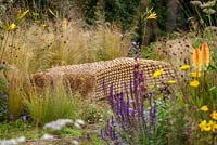 Sculptured straw bench amongst naturalistic grasses and perennials, The Jordans Wildlife Garden, RHS Hampton Court Flower Show 2014