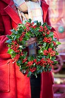 Carol holding holly wreath. Ilex