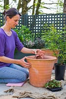 Adding crocks to container ready for planting