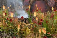 Conceptual garden Wrath Eruption of Unhealed Anger red and orange planting of Kniphofia and Echinacea with grasses. Water vapour representing smoke bellowing from volcano of anger. Designer: Nilufer Danis Gold award