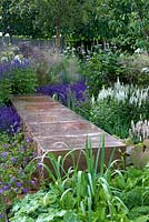 Vestra Wealth's Vista Garden. A copper bench is set in planting or perennials with cool colour palette. Designer: Paul Martin Sponsor: Vestra Wealth Gold award  
