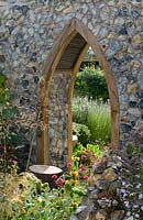 The Flintknappers garden - A story of Thetford. View glimpsed through door of ruined medieval priory church with naturalistic planting including centranthus and stipa. Designer: Luke Heydon Sponsor: Thetford business community Silver-gilt award  