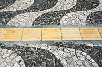 A tactile pathway for the blind leads somewhat clumsily through a Portuguese pavement - design in Salvador in Brazil. 
