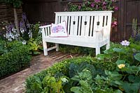 Hedgehog Garden - view of garden bench, brick paving and box hedge with savoy cabbage, chard and squash - Designer - Tracy Foster - Sponsor - Peoples Trust for Endangered Species PTES - British Hedgehog Preservation Society BHPS