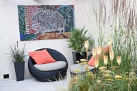 Hedgehog Garden - view of contemporary outdoor living space with planting of grasses, achillea, eryngium and Kniphophia. Designer - Tracy Foster - Sponsor - Peoples Trust for Endangered Species PTES - British Hedgehog Preservation Society BHPS
