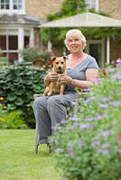 Garden owner Pam Tatam, with her dog Daisy. Hall Farm Garden at Harpswell near Gainsborough in Lincolnshire. July 2014.