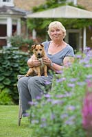 Garden owner Pam Tatam, with her dog Daisy. Hall Farm Garden at Harpswell near Gainsborough in Lincolnshire. July 2014.