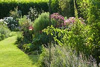 The Sundial Garden. Mixed herbaceous perennials, annuals and dahlias. Hall Farm Garden at Harpswell near Gainsborough in Lincolnshire. August 2014.