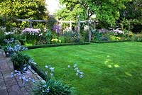 View to herbaceous border.  Terrace lined with copper planters filled with Agapanthus 'Streamline'