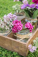 Floral arrangement of scented Pelargoniums, Hydrangea and Dianthus barbatus in vintage glass jars