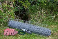 Fencing off a Rabbit hole - Materials needed are gloves, chicken wire, twine and wire cutters