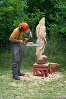 Chainsaw carving, Man carving hare form solid tree trunk