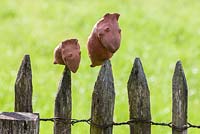 Clay figures topping wooden picket fence