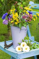 Cut flowers in bucket on garden seat